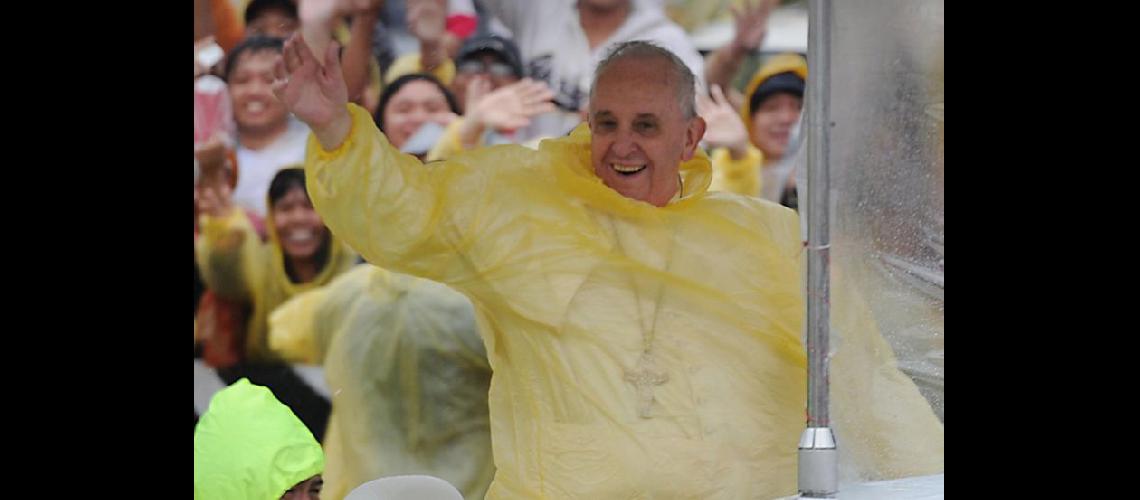  El Papa con un piloto de plstico para protegerse de la intensa lluvia (NA)