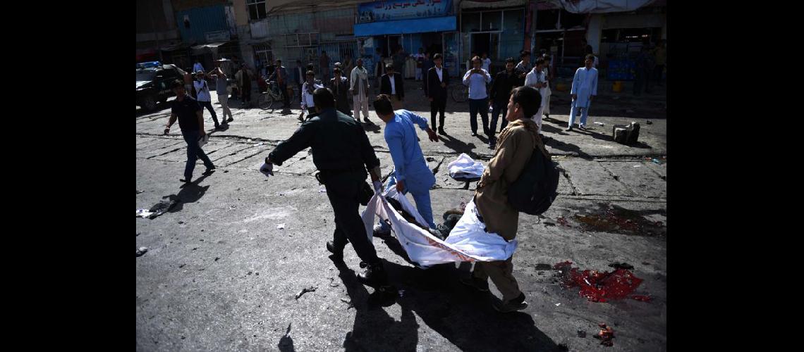  Voluntarios ayudan a retirar un herido en el ataque que dejó 80 muertos y 231 heridos en Kabul (NA)