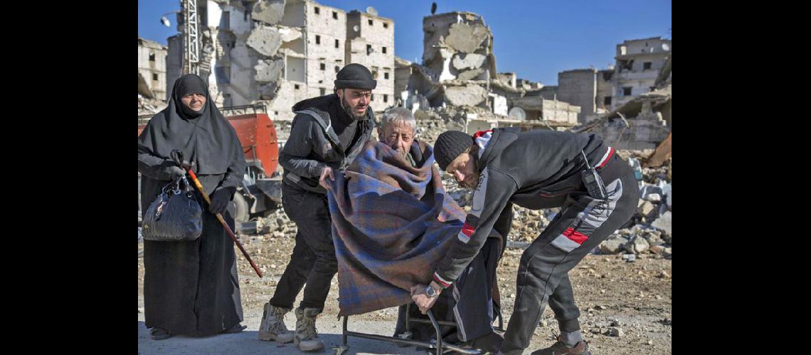 Una persona es ayudada a ser evacuada de la ciudad de Alepo que quedó en ruinas (NA)