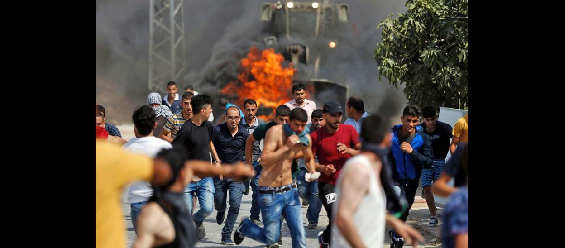 Los jóvenes palestinos huyendo de un bulldozer del ejército israelí durante los enfrentamientos (NA)