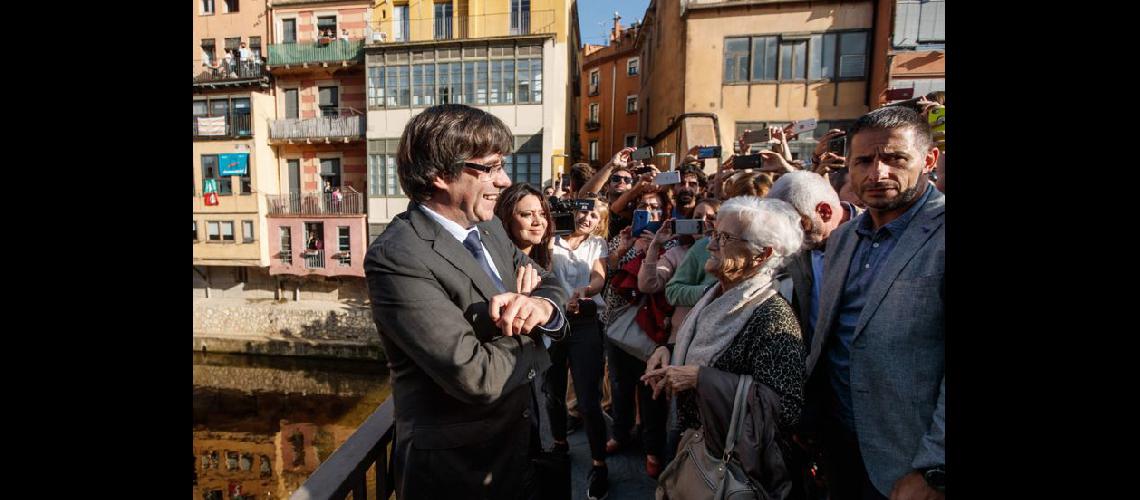  El destituido Carles Puigdemont  y su esposa Marcela Topor dialogaron con lugareños en Girona (NA)