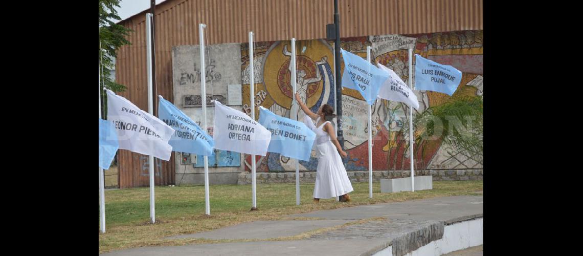  Antonella Maloni del Cuerpo Municipal de Danzas izó las banderas en memoria de los desaparecidos mientras un grupo de cantantes locales interpretaba La Memoria (LA OPINION)