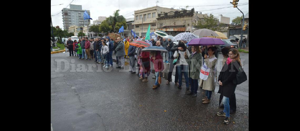  A pesar de la persistente llovizna un centenar de personas se congregaron en torno al Monolito de Alsina y Sarmiento para reflexionar sobre la situación actual de los trabajadores (LA OPINION)
