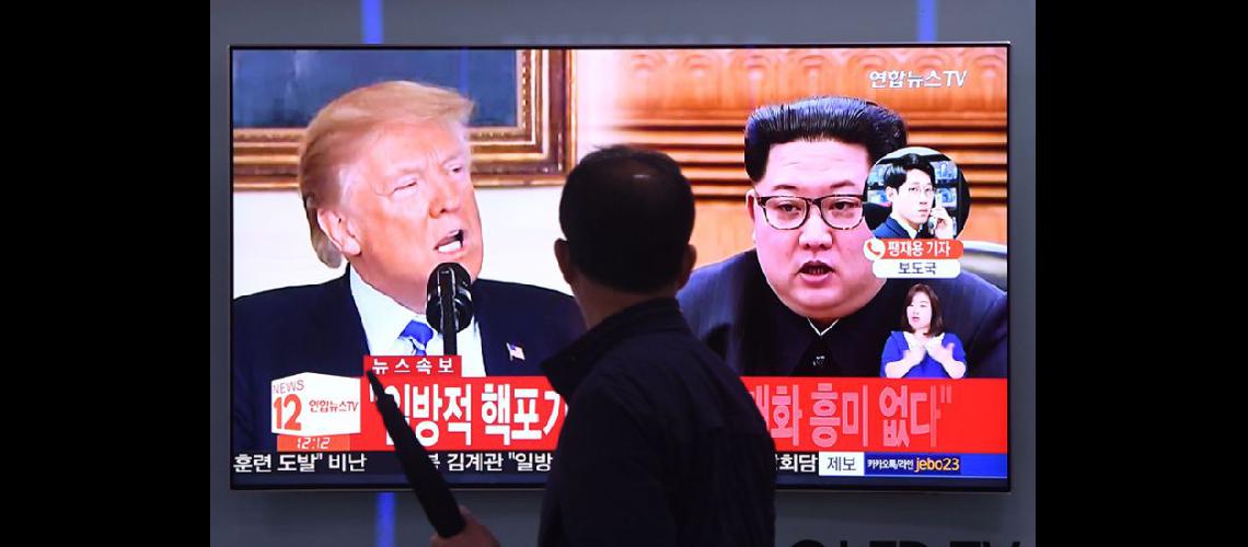  Un hombre pasa frente a un televisor que muestra a Donald Trump y a Kim Jong Un en una estación de Seúl (NA)