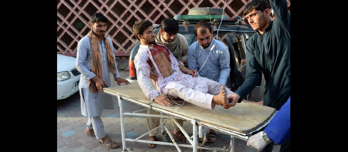  Voluntarios afganos trasladan a un herido en una camilla luego de que un atacante se inmoló en Jalalabad (NA)