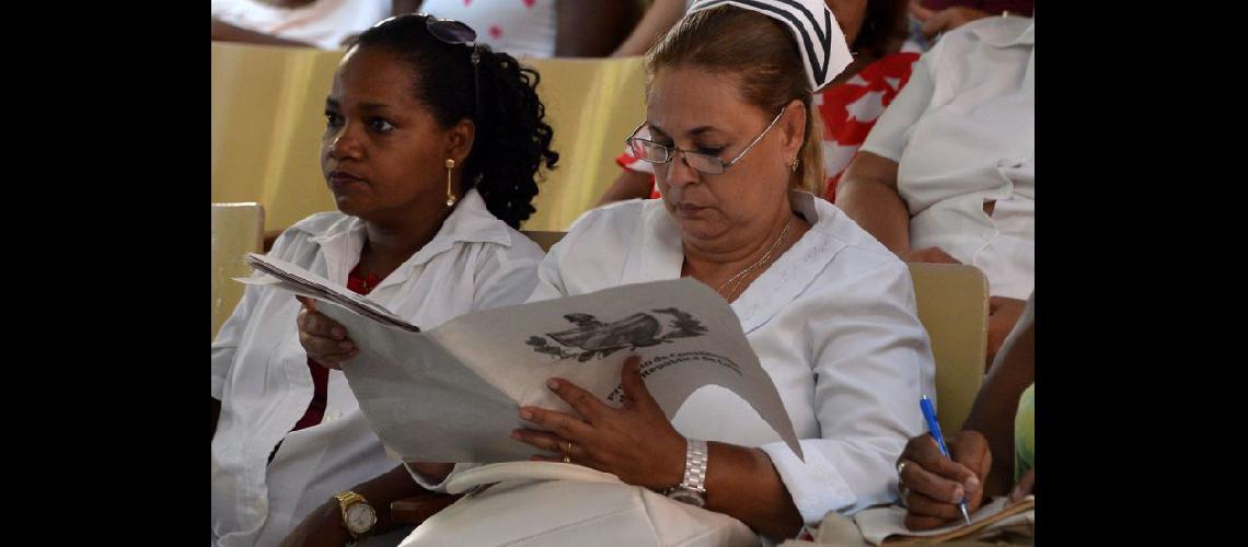  Una enfermera lee un tabloide con el proyecto de constitución durante la discusión en un policlínico de La Habana (NA)