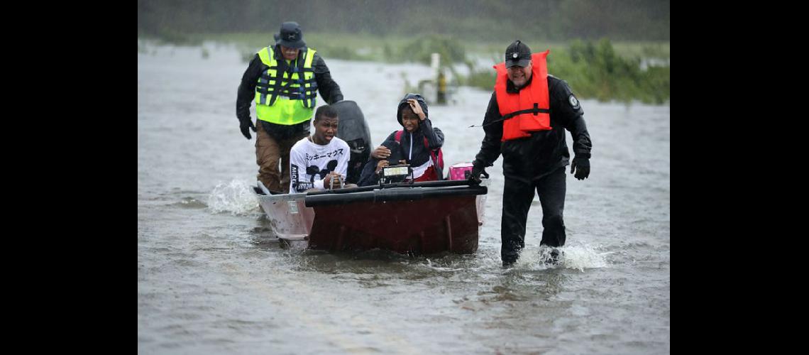  Voluntarios ayudan a rescatar a tres niños de su hogar inundado en James City luego del paso de Florence (NA)