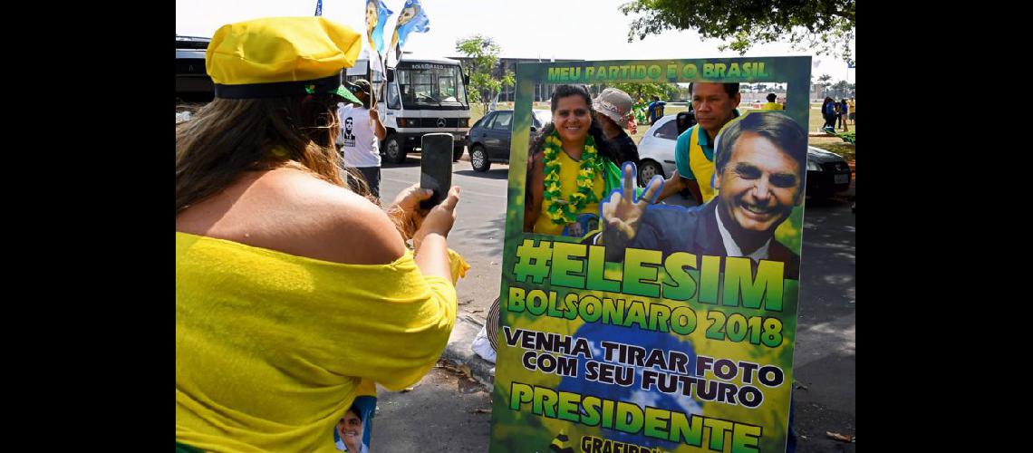  Una partidaria de Bolsonaro toma una instantnea con un signo alusivo durante un mitin de campaña en Brasilia (NA)