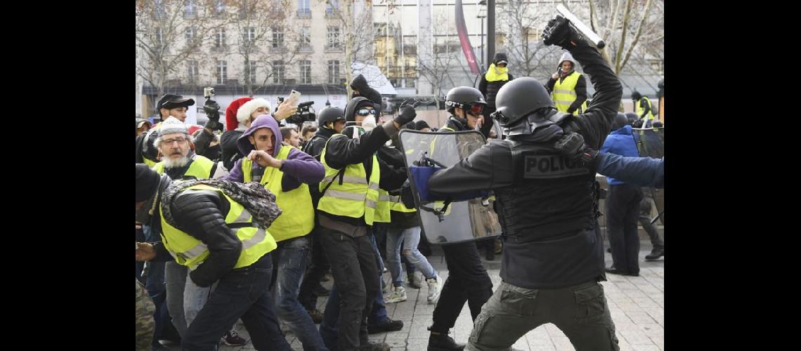  La policía antidisturbios se enfrenta con los chalecos amarillos en cercanías del Arco del Triunfo en París (NA)