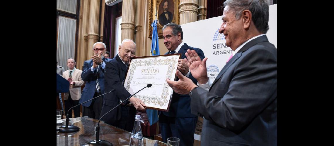  Jaunarena recibe de manos del senador Julio Martínez el diploma que lo distingue ante el aplauso del expresidente Eduardo Duhalde (CHARLY DIAZ AZCUE-SENADO)