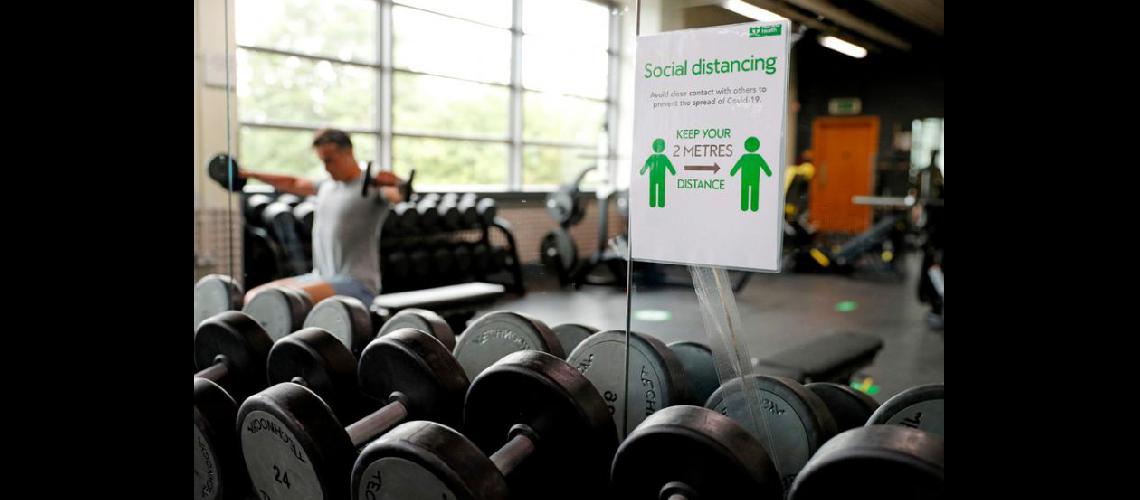  Un cartel indica la distancia que deben mantener los clientes de un gimnasio en una localidad cercana a Londres (AFP)