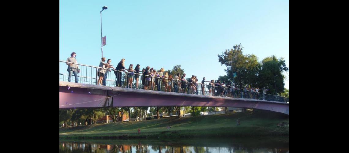  Desde el Puente de la Mujer integrantes de la Juntada Feminista cumplieron con el rito de arrojar mariposas de papel al Arroyo (LA OPINION)