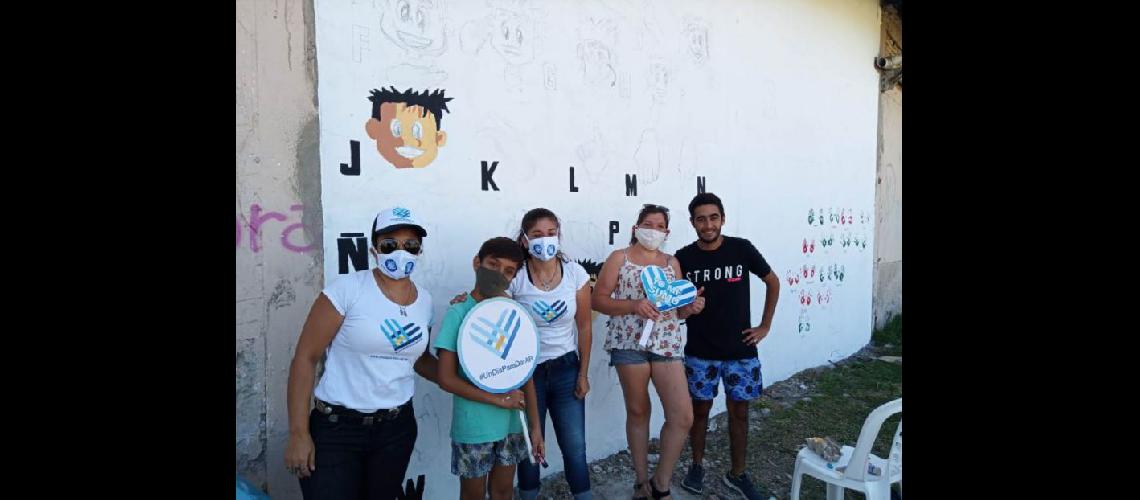  Referentes de Un Día para Dar Pergamino junto a Juani Méndez posan en el mural de Lengua de Señas  (LA OPINION)