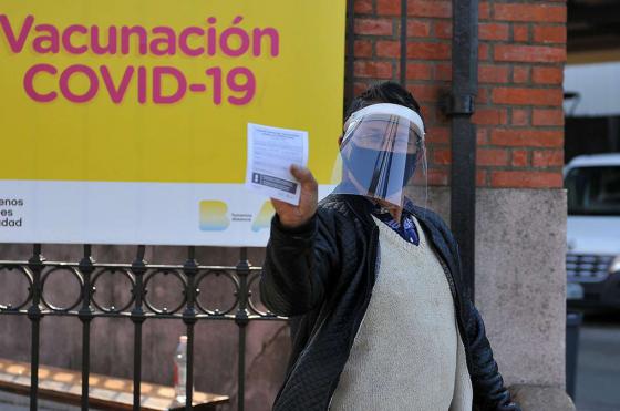 Un hombre muestra su carnet de vacunación tras aplicarse una dosis del suero contra el Covid