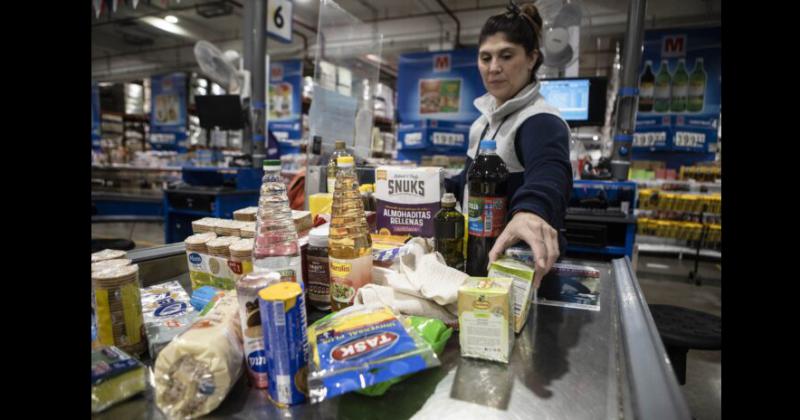 Una trabajadora cobrando productos en la zona de cajas de un supermercado