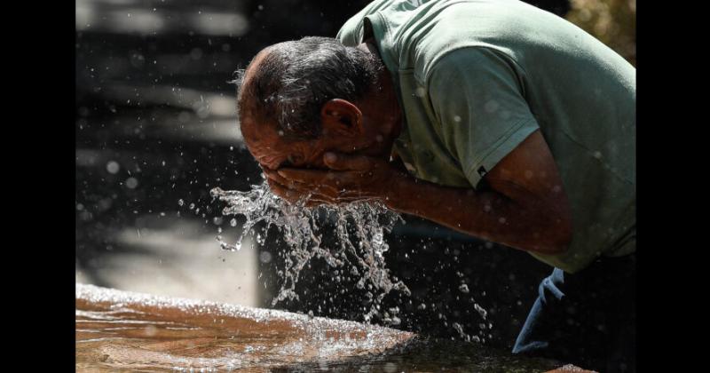 Un hombre se refresca en una fuente durante una ola de calor