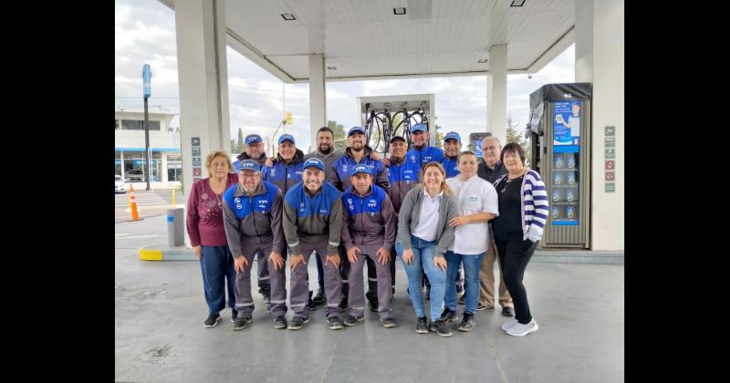 Los empleados de la expendedora de combustibles posan junto a quienes dirigen los destinos de la firma