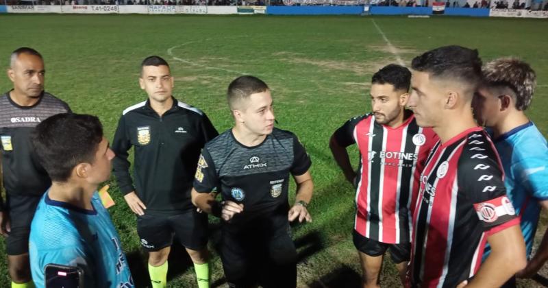 El rbitro Cristian Verna dialoga con los capitanes y les comunica la suspensión